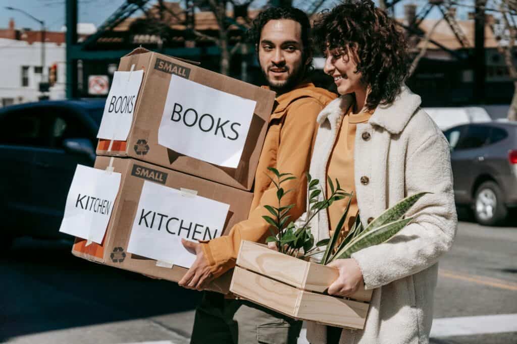 A couple is carrying their things to their new apartment in the concept of moving to Sutton.