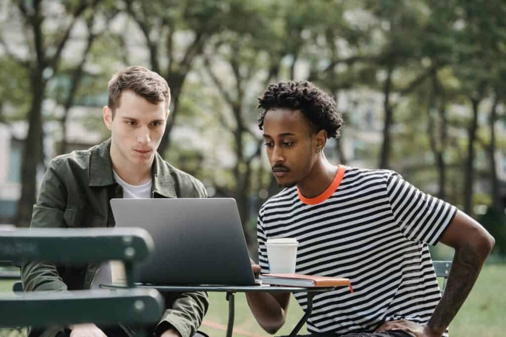 Friends are having coffee while using a laptop