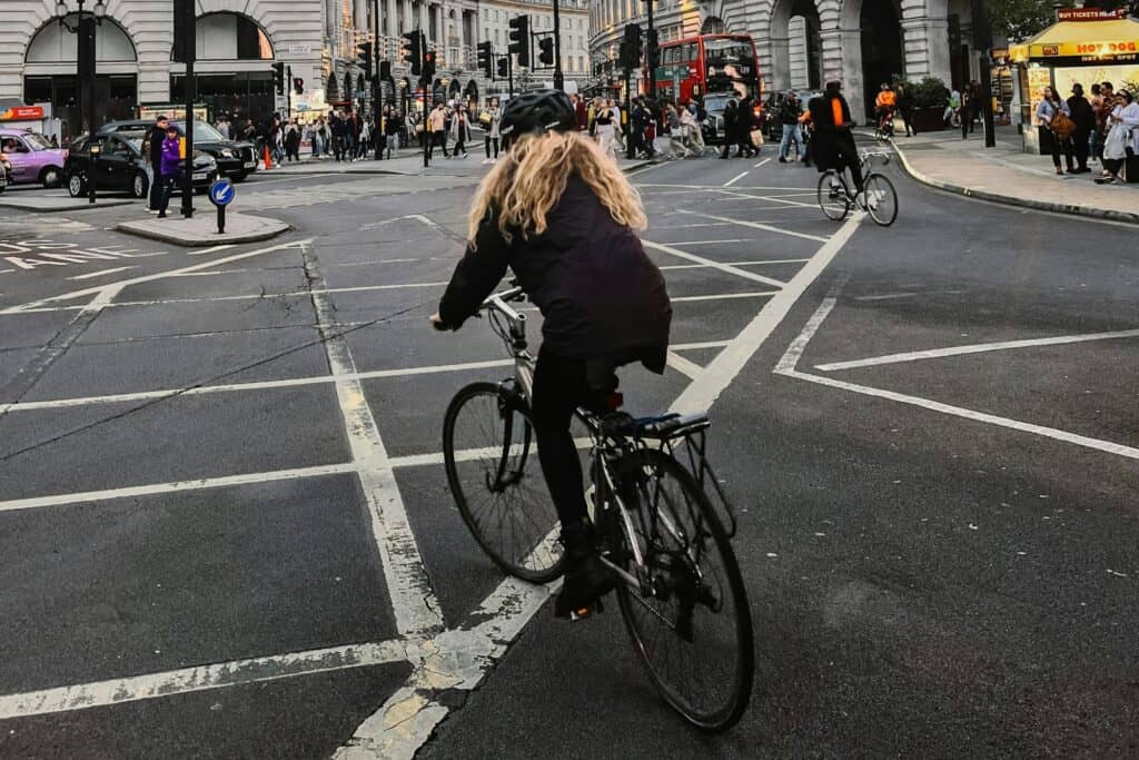 Cyclists, pedestrians, and the double-decker in a busy street