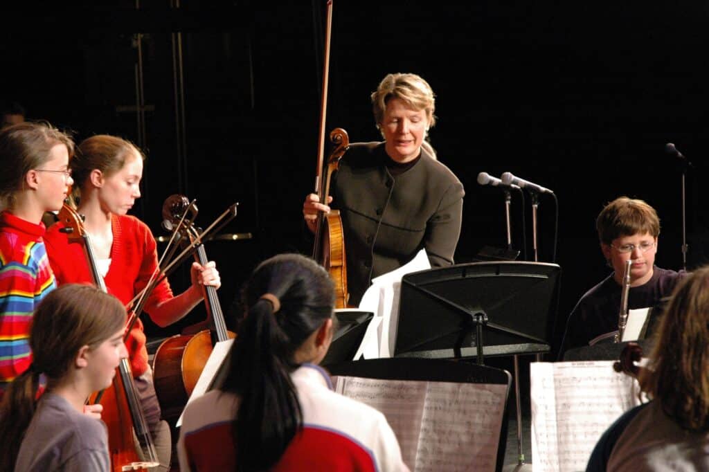 A teacher and her students with musical instruments