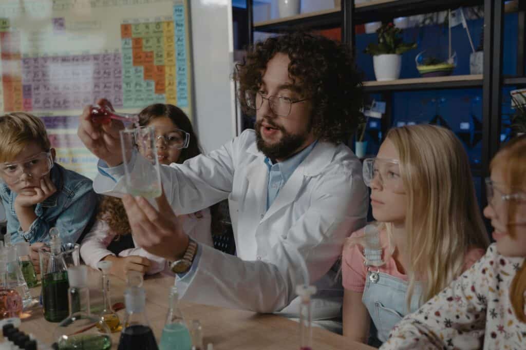 A teacher and his students in the chemistry laboratory