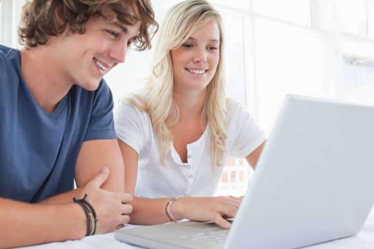 A young couple in front of the computer in the concept of 'Changing Address and Updating Utilities After Moving to Sutton'.