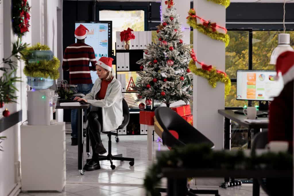 Busy employees in an office with holiday decoration in the concept of uninterrupted operations